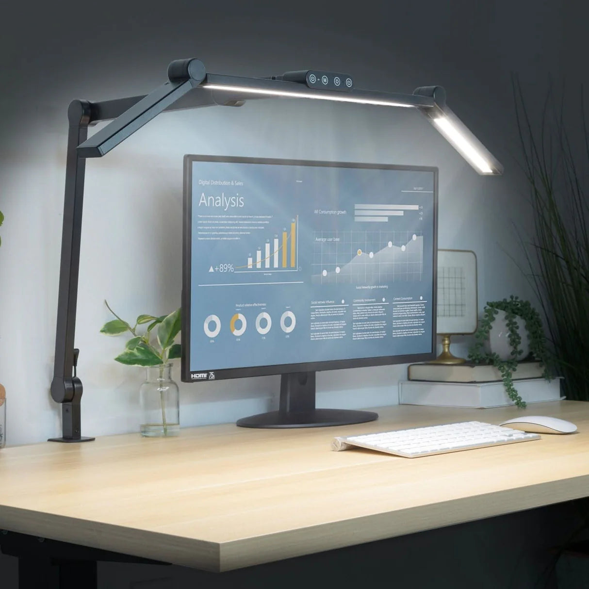 Desk setup with a monitor, keyboard, and lamp in a home office setting.